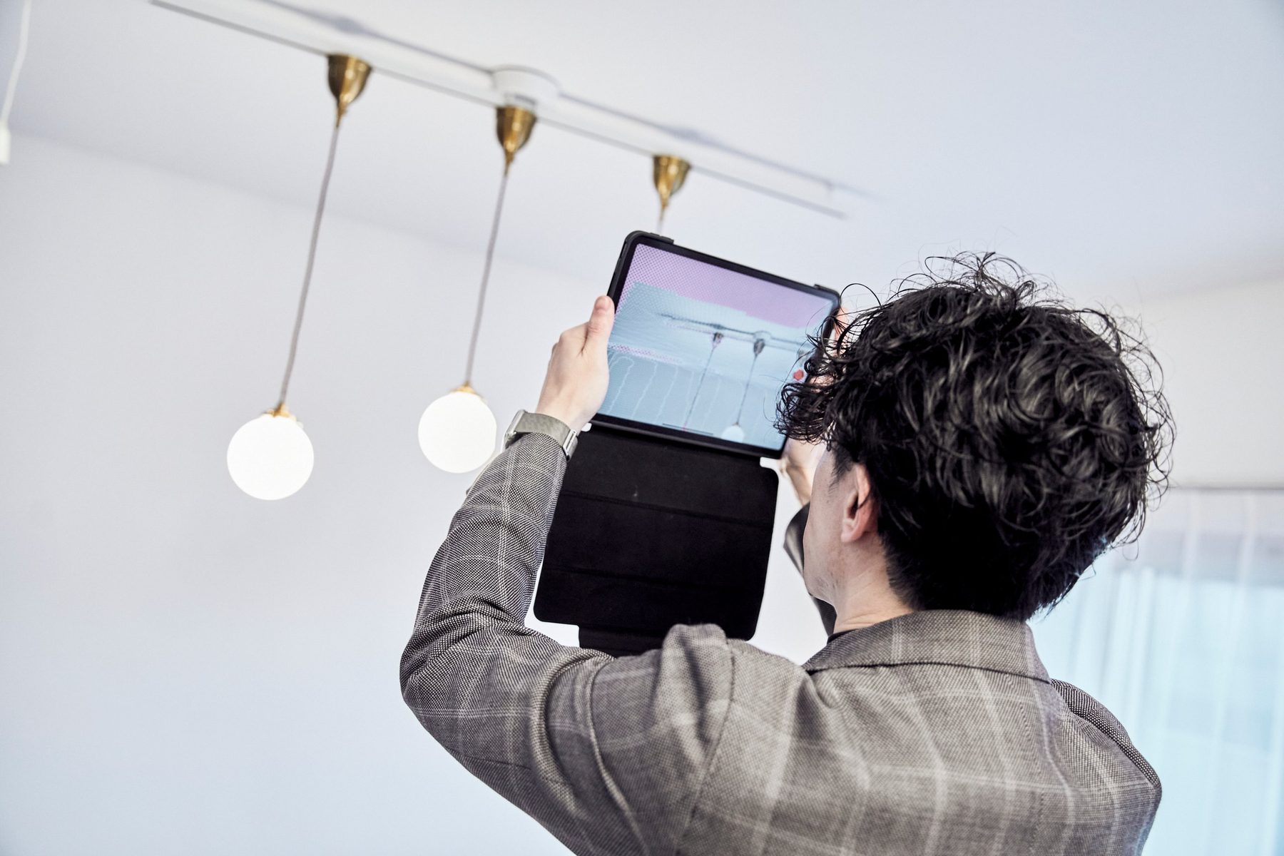 タブレットで室内を3Dスキャンするスタッフ